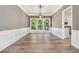 Dining area showcasing wainscoting, a modern chandelier, and hardwood flooring at 1931 Abinger Way, Lawrenceville, GA 30043