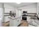 Eat-in kitchen features stainless appliances, white cabinetry, and a center island at 1931 Abinger Way, Lawrenceville, GA 30043