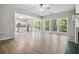 Open-concept living room with hardwood floors, view of kitchen and wall of windows overlooking backyard at 1931 Abinger Way, Lawrenceville, GA 30043