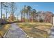 Spacious backyard offering a gravel walkway, mature trees, and a fenced perimeter for added privacy at 3373 Shoals Ridge Dr, Dacula, GA 30019