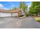 A view of the exterior of the home, including the garage, a bench, and well-manicured landscaping at 3746 Vineyards Lake Nw Cir # U6, Kennesaw, GA 30144