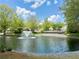 Beautiful pond featuring a fountain, deck with gazebo, and surrounding lush greenery in the community at 3746 Vineyards Lake Nw Cir # U6, Kennesaw, GA 30144