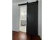 Bathroom with hardwood floors and sliding barn door accessing vanity with modern fixtures and a tiled shower at 1001 Park Gate Pl, Stone Mountain, GA 30083