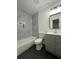 Updated bathroom with marble tile surround and gray vanity at 1001 Park Gate Pl, Stone Mountain, GA 30083