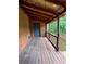 Covered back porch features wood flooring and brick supports at 1001 Park Gate Pl, Stone Mountain, GA 30083