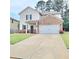 Charming two-story home with a brick and vinyl facade, an attached two car garage, and a well-manicured front lawn at 110 Halibut Cir, Covington, GA 30016
