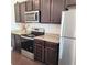Modern kitchen features stainless steel appliances, dark cabinets, and granite countertops at 110 Halibut Cir, Covington, GA 30016