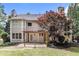 Exterior of the home showing the patio, bay windows, and a tree with red leaves at 1235 Legend Run, Alpharetta, GA 30005