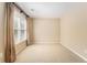 Bedroom features a large window with blinds, light-colored walls, carpeted flooring, and neutral paint at 1235 Legend Run, Alpharetta, GA 30005