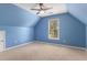 Angled walls define this blue bedroom featuring a ceiling fan and window at 1235 Legend Run, Alpharetta, GA 30005