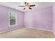 Amethyst-colored bedroom featuring a ceiling fan and window providing natural light at 1235 Legend Run, Alpharetta, GA 30005
