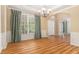 Formal dining room featuring wood floors, decorative trim, a chandelier, and natural light from a large window at 1235 Legend Run, Alpharetta, GA 30005