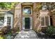Welcoming front entrance featuring a black front door, sidelights, transom window, and brick facade at 1235 Legend Run, Alpharetta, GA 30005