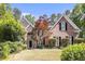 Charming brick home featuring mature landscaping, a well-maintained lawn, and classic black shutters at 1235 Legend Run, Alpharetta, GA 30005
