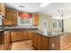 Bright kitchen with island, wood floors, granite counters, wood cabinets, and a view to the living area at 1235 Legend Run, Alpharetta, GA 30005