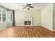 Cozy living room with a fireplace, hardwood floors, large windows, and a ceiling fan at 1235 Legend Run, Alpharetta, GA 30005