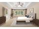 Bright main bedroom featuring a tray ceiling, ceiling fan, and a bay window offering lots of natural light at 1235 Legend Run, Alpharetta, GA 30005