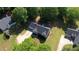 Aerial view of a house roof with surrounding green lawn and mature trees nestled in a quiet neighborhood at 65 Ashland Farm Rd, Oxford, GA 30054
