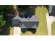 Bird's eye view of a home featuring a dark roof and landscaped surroundings within a lush, green neighborhood at 65 Ashland Farm Rd, Oxford, GA 30054