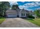 Inviting home with a two car garage and well-manicured front yard on a sunny day at 65 Ashland Farm Rd, Oxford, GA 30054