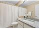 Well-lit bathroom featuring a granite countertop, white cabinets, and a shower with a white curtain at 66 Devon Ln, Avondale Estates, GA 30002