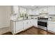 Stylish kitchen with white cabinets, granite counters, stainless steel appliances, and hardwood floors at 66 Devon Ln, Avondale Estates, GA 30002