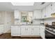 Bright kitchen features white cabinets, stainless steel appliances, granite counters, and hardwood floors at 66 Devon Ln, Avondale Estates, GA 30002