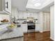 Modern kitchen featuring white cabinets, granite countertops, and stainless steel appliances at 66 Devon Ln, Avondale Estates, GA 30002
