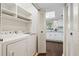 A well lit laundry room with shelving, washer and dryer, and access to kitchen at 66 Devon Ln, Avondale Estates, GA 30002