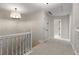 Light-filled hallway with neutral carpet and white trim, featuring a modern light fixture and access to other rooms at 1077 Shady Valley Ne Pl, Atlanta, GA 30324