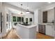 View of the kitchen showing the center island with cooktop, quartz counters and access to the backyard at 1077 Shady Valley Ne Pl, Atlanta, GA 30324