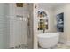 An elegant shower with white subway tile sits next to a soaking tub in the main bathroom at 1077 Shady Valley Ne Pl, Atlanta, GA 30324