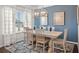 Bright dining area with modern lighting, views of the backyard, and seating for six around a wooden table at 1315 Elowen Dr, Austell, GA 30168