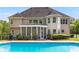 Exterior view of home with a screened-in porch and a swimming pool, surrounded by lush landscaping and a fenced yard at 679 Gold Valley Pass, Canton, GA 30114