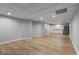 Finished basement area with wood-look flooring, tiled ceiling, and a wet bar with white cabinets and stainless steel refrigerator at 679 Gold Valley Pass, Canton, GA 30114