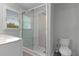 Updated bathroom featuring a glass-enclosed shower, window, and toilet, beautifully illuminated at 679 Gold Valley Pass, Canton, GA 30114