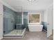 Bathroom showcasing large glass shower with a bench, and a modern tub at 679 Gold Valley Pass, Canton, GA 30114