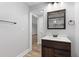 Bathroom featuring a stylish vanity with a rustic wood cabinet and a decorative mirror over the sink at 679 Gold Valley Pass, Canton, GA 30114