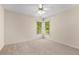 A bedroom featuring carpet flooring, a ceiling fan, and natural light from two windows at 679 Gold Valley Pass, Canton, GA 30114
