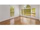 Bright bedroom featuring hardwood floors, large windows offering beautiful outdoor views, and ample natural light at 679 Gold Valley Pass, Canton, GA 30114