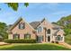 Charming brick home featuring manicured lawn, dormer windows, arched windows, and a well-kept landscape at 679 Gold Valley Pass, Canton, GA 30114