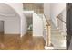 Bright foyer with hardwood floors, staircase with white railings, and arched doorway leading to other rooms at 679 Gold Valley Pass, Canton, GA 30114