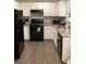 Well-lit kitchen with granite countertops, black appliances, and ample cabinet space at 985 Romer Pl, Stone Mountain, GA 30083