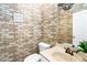 Cozy bathroom features brick wallpaper, single sink vanity, toilet and mirror at 1114 Ivey Chase Pl, Dacula, GA 30019