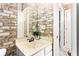 Classic bathroom with brick wallpaper, single sink vanity, and a large mirror at 1114 Ivey Chase Pl, Dacula, GA 30019
