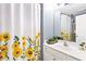 Bathroom with bright sunflower themed shower curtain and modern vanity at 1114 Ivey Chase Pl, Dacula, GA 30019