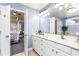 Bright bathroom with double vanity, tiled flooring, and a glimpse into the main bedroom at 1114 Ivey Chase Pl, Dacula, GA 30019