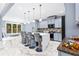 Open kitchen with gray cabinets, marble countertops, tile floors, pendant lights and breakfast bar with stools at 1114 Ivey Chase Pl, Dacula, GA 30019