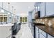 Open kitchen featuring light blue cabinets, granite countertops, and a breakfast bar with pendant lighting at 1114 Ivey Chase Pl, Dacula, GA 30019