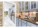 Stylish kitchen with light blue cabinets, granite countertops, stainless steel appliances and brick accent wall at 1114 Ivey Chase Pl, Dacula, GA 30019